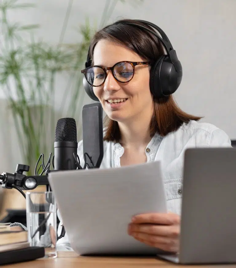 Woman recording audio in front of a microphone
